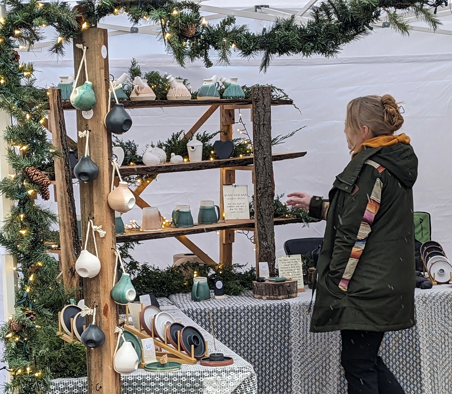 Female walks in front of merchandise displayed in a white tent