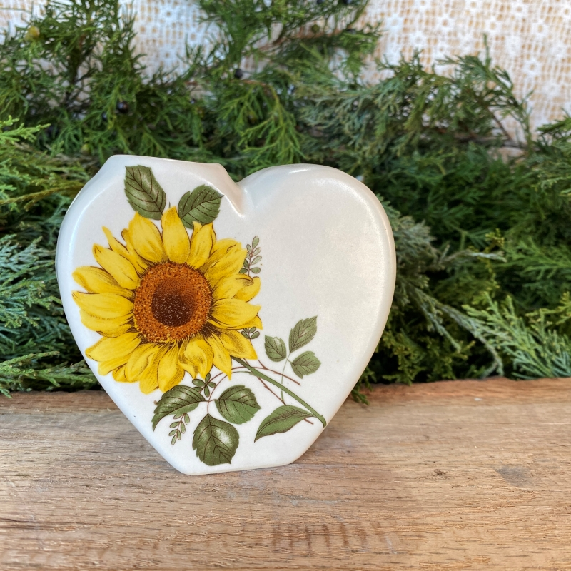 White ceramic heart with a sunflower decal.